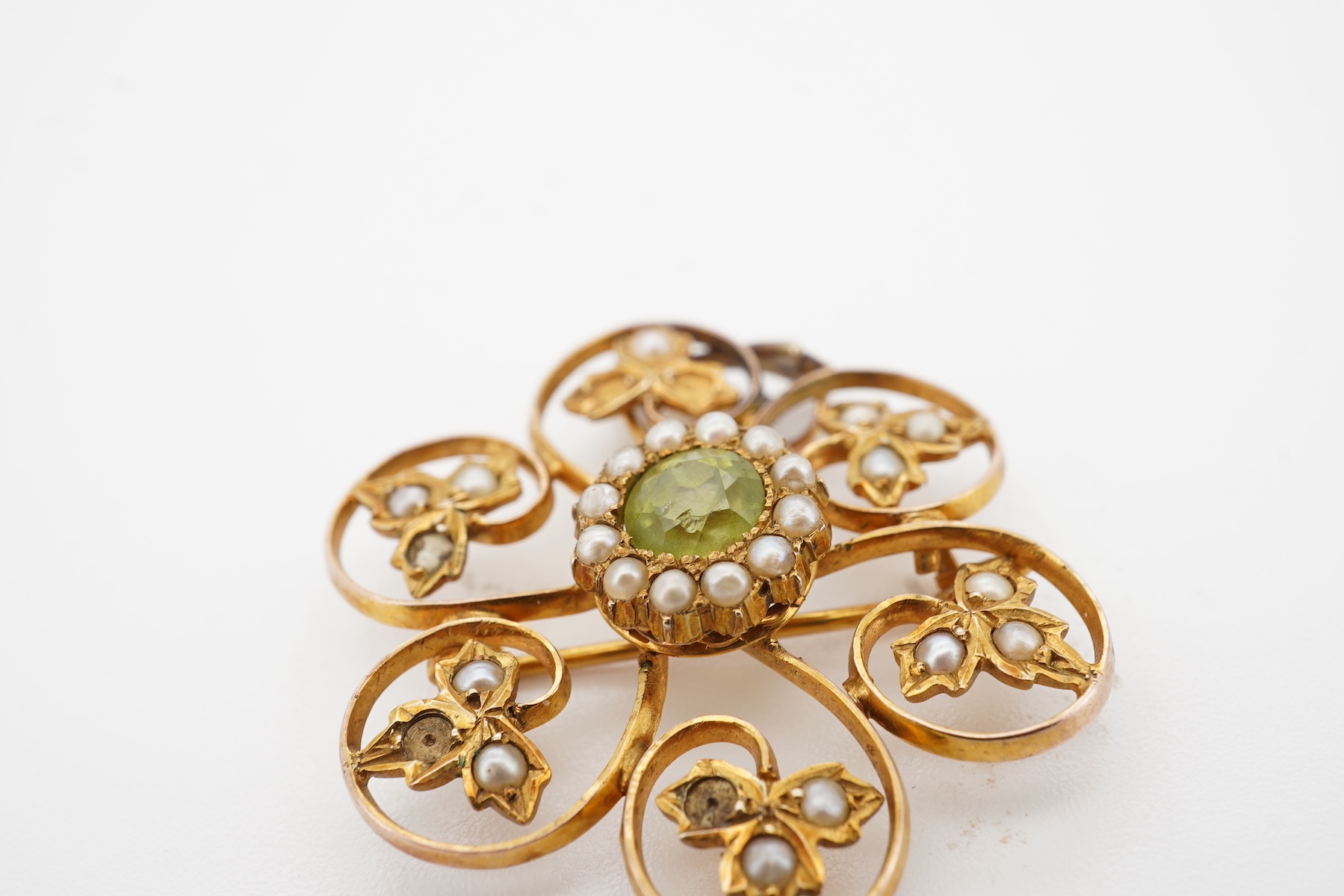 An Edwardian seed pearl and peridot pendant/brooch, early 20th century